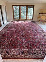 Full view of red wool area rug covering room floor