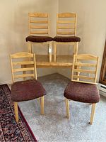 Dining table with two chairs on top and two chairs positioned on the floor in front.
