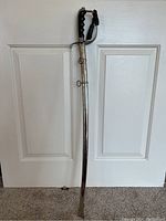 Full view of the USN naval officer's sword and scabbard showing the full length and overall condition.