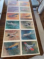 Full set of 12 aircraft prints laid out on a wooden floor showing a variety of Canadian Pacific Airlines planes.