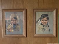 Two framed Dorothy Oxborough Indigenous prints side by side on wall, clear view of both subjects.