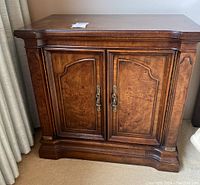 Front view of one side table closed showing wood veneer top and panel doors