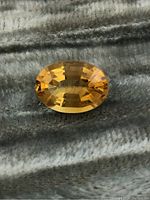 Top view of oval citrine gemstone showing facets and color.