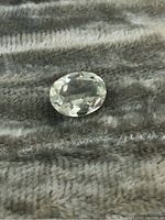 Front view of the oval faceted prasiolite gemstone showing the pale green translucent color and clarity.