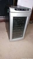 Front view of beverage fridge showing glass door and control panel on top.