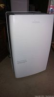 Front view of the white Noma dehumidifier with brand name visible on the top front panel.