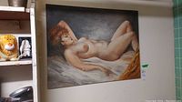 Full view of the unsigned acrylic painting depicting a reclining nude woman with curly reddish-brown hair on canvas.