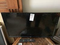 Front view of Seki 32-inch TV showing screen with label and placed on wooden table.