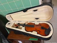 1/2 size Strong Wind violin inside an open zippered case showing violin body, chin rest, and plush interior.
