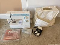 Bernette 715 sewing machine alongside foot pedal, instruction manual, small accessory box, and protective carrying case.