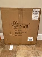 Photo of unopened cardboard box labeled Yiotl Dog Training Set with shipping labels visible.