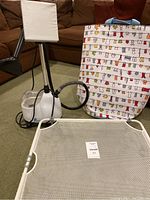 Full view showing all three items together on carpet in living room setting: steamer, hamper and drying rack.