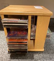 Photo of the wooden rotating CD holder loaded with multiple CDs visible from the side
