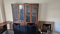Front view of the buffet and hutch unit showing glass center door of the hutch and metal grid side panels.