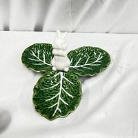 Overview of Majolica platter showing green leaf-shaped ceramic sections and white bunny center.