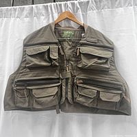 Front view of the Orvis fishing vest showing multiple zippered and flap pockets and durable fabric.