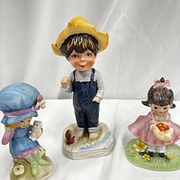 Front and side view of the three Moppets Goin' Wishin' figurines, showing color details and poses.