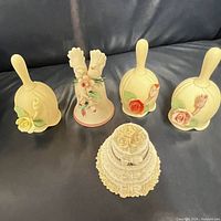 Five vintage Capodimonte porcelain bells and a decorative cake trinket box displayed on a surface.