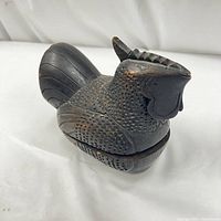 Side view of vintage hand carved wooden rooster trinket box with detailed carving and box separation line visible.