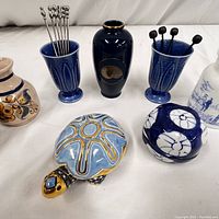 Photo showing a collection of vintage ceramic bar and kitchen décor items including vases, bowls, and a turtle-shaped trinket box with decorative stir sticks and picks.