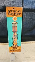 Box showing vintage American gas pump graphic, labeled as liquid dispenser circa 1920.