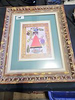 Framed Peace print with ornate wood frame and matting showing colorful folk art style image and text.