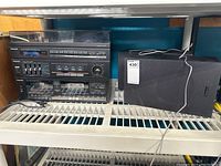 Photo showing full stereo system with main unit and one speaker, the main unit has a missing volume knob but can still be turned