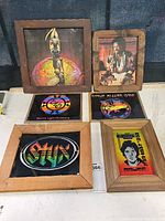 Six framed vintage rock pictures arranged on a flat surface including Jimi Hendrix, Electric Light Orchestra, Styx, Steve Miller Band, Bruce Springsteen, and a colorful mystical figure.