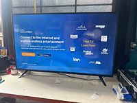 Front view of the 50-inch Vizio smart TV powered on, displaying the WatchFree+ screen showing entertainment options.