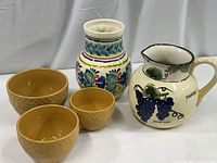 Set of pitcher, vase, and nesting bowls shown together on white surface