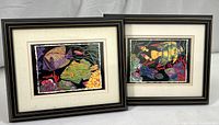 Photo showing the two framed colorful fish prints side-by-side with black gold-edged frames and white mats.