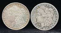 Front obverse view of 1882 Morgan silver dollar and 1901-O Morgan silver dollar, showing Liberty heads and dates.