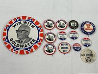 Overview of all 12 campaign pins showing various sizes and designs including large Win With Goldwater button and smaller pinbacks with portraits and slogans