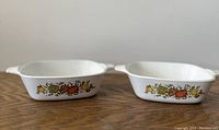 Two vintage Corning Ware petite pans side by side showing Spice of Life pattern on sides.