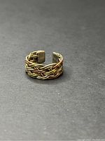 Front angled view showing braided multi-metal construction and open band