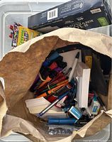 View into paper bag with various pens and small office items inside