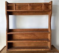 Front view of the vintage wooden shelf showing three shelves and top rail with hooks.