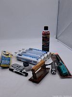 Wide view of lot showing all items together including caulk tubes, cleaning wax, tools and sponge