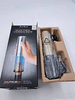 Electric corkscrew in original box with molded insert, charger and wrapped unit visible