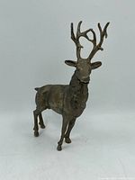 Full front view of the vintage cast metal buck statue on a white background showing full body and standing pose.