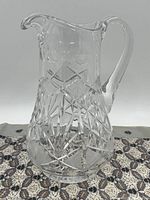 Profile view of the pitcher displaying the overall shape, handle, and spout design with cut crystal pattern