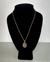 Full portrait of the necklace on black display bust showing pendant and chain