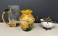 Four gilt Bohemia glass vases, one clear glass mug with ornate handle, and one leaded glass footed container
