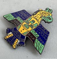 Close-up of one colorful enamel and sterling silver Thunderbird brooch from the lot showing detailed wing and head patterns