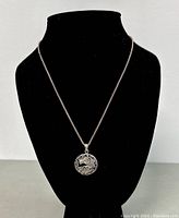 Full view of the sterling silver necklace displayed on a black bust showing the chain and pendant hanging.