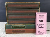 Front view of the two fairy tales books in slip cases under the Shakespeare book collection set in a worn slip case.