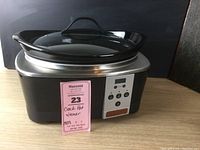 Front view of black and stainless steel Crock-Pot slow cooker with digital timer and glass lid on top.