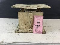 Front view of the scale showing multiple layers of chipped white paint and the weighing platform.