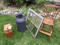 Wide shot of the full lot on grass including the milk can, wooden high chair, old window, and wooden box.