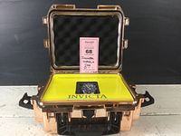 Photo of the copper-colored hard plastic case opened showing foam lining and Invicta certificate card holder with watch inside